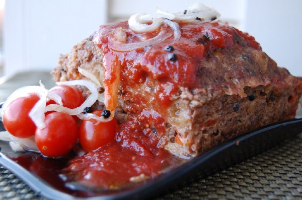 Decorated roasted red pepper meatloaf with pickled tomatoes