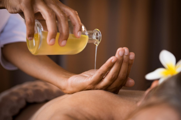 pouring diy massage oil on the hand