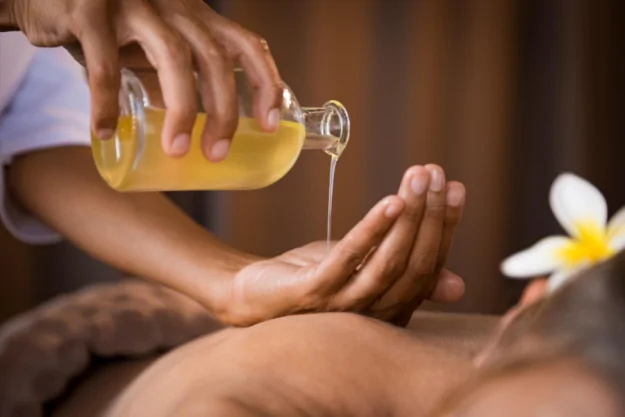Pouring diy massage oil on the hand
