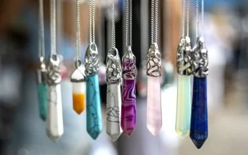Multi colored gemstones and crystal pendants blurred background