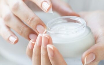 Beautiful woman hands applying moisturizer