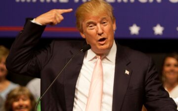 Donald Trump pointing at his head