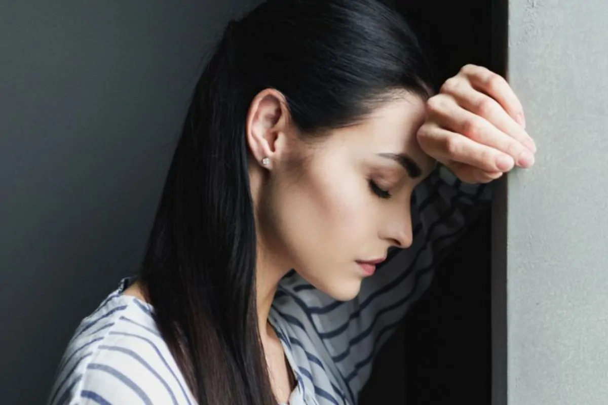 Sad woman leaning against the wall